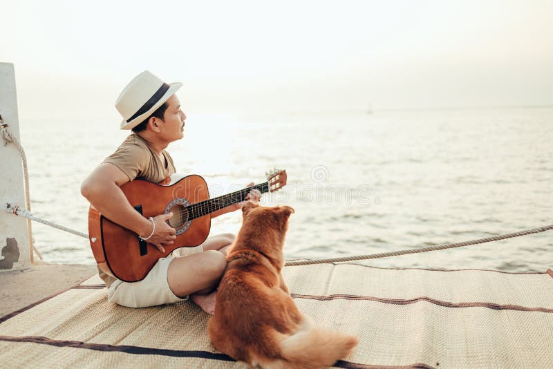 Y así hada diversión Un Hombre Usa Sombrero De Paja Y Toca Música De Guitarra Cerca De La Puesta  De Sol Del Mar Con Una Mascota De Perro Imagen de archivo - Imagen de  perro, océano: