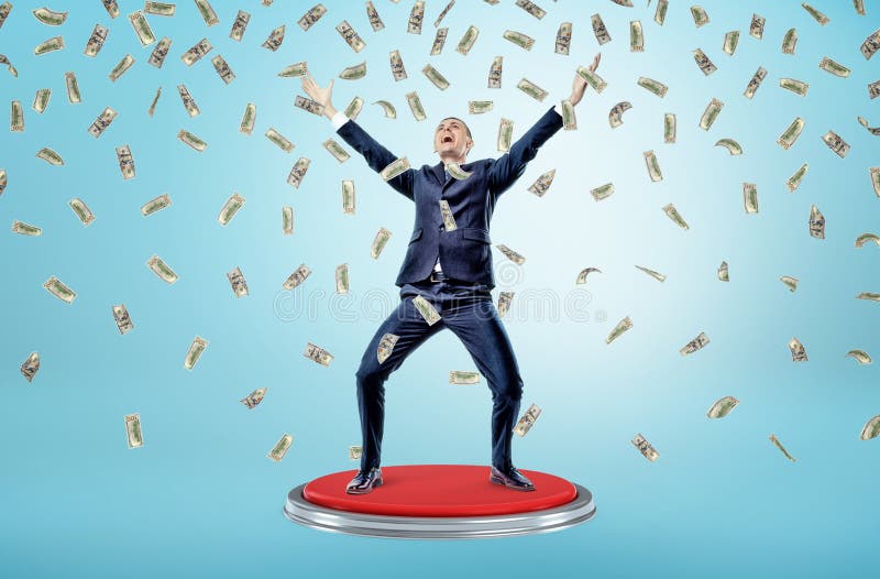 Un homme d'affaires heureux et victorieux se tient sur un bouton rouge géant sous beaucoup qui tombent 100 billets d'un dollar photos stock Un homme d'affaires heureux et victorieux se tient sur un bouton rouge géant sous beaucoup qui tombent 100 billets d'un dollar photos stock