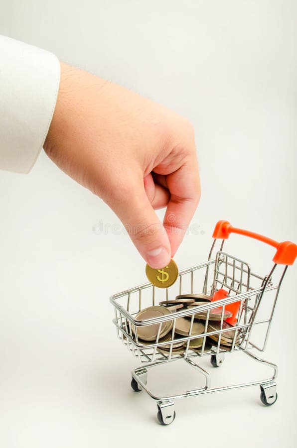 Un homme d'affaires met une pièce de monnaie du dollar dans un chariot à supermarché avec l'argent accumulation du capital, augme photo libre de droits Un homme d'affaires met une pièce de monnaie du dollar dans un chariot à supermarché avec l'argent accumulation du capital, augme photo libre de droits