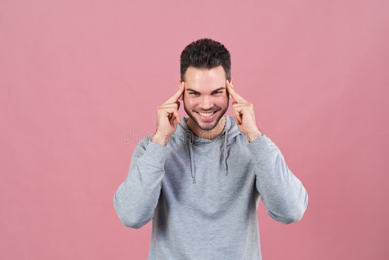 Un homme de sourire heureux presse ses doigts à ses temples afin d'essayer de se concentrer et sourit largement Le concept de l'i image libre de droits Un homme de sourire heureux presse ses doigts à ses temples afin d'essayer de se concentrer et sourit largement Le concept de l'i image libre de droits