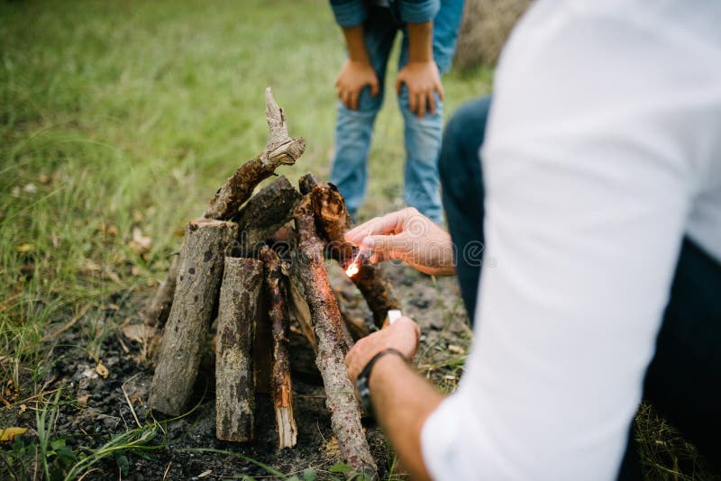 Un homme fait un feu dans la forêt pendant l'après-midi d'été images libres de droits Un homme fait un feu dans la forêt pendant l'après-midi d'été images libres de droits