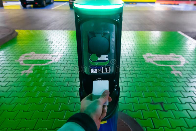 Un homme paie pour charger une voiture électrique Tenue à la main prise en charge à la station de charge Concept d'électricité ve image stock Un homme paie pour charger une voiture électrique Tenue à la main prise en charge à la station de charge Concept d'électricité ve image stock