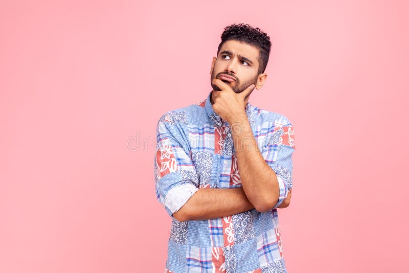 Un homme pensif barbu en bleu casual style chemise tenant le menton avec la main doit penser stratégie de planification réflexion photos stock