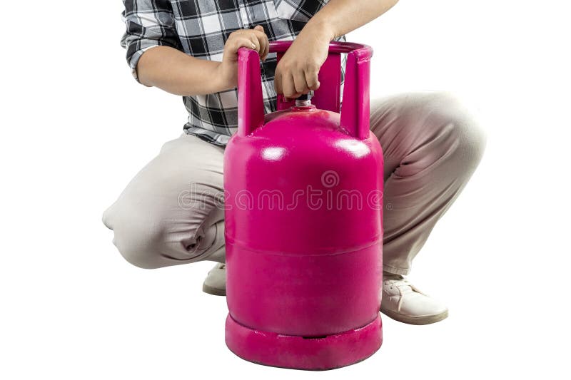 Un homme s'agenouille à côté d'un cylindre de gaz rose ouvrant le sceau du cylindre de gaz rose images stock