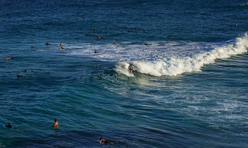 Un homme surfant sur la vague blanche de mousse dans l'océan bleu avec des personnes nageant photos libres de droits Un homme surfant sur la vague blanche de mousse dans l'océan bleu avec des personnes nageant photos libres de droits