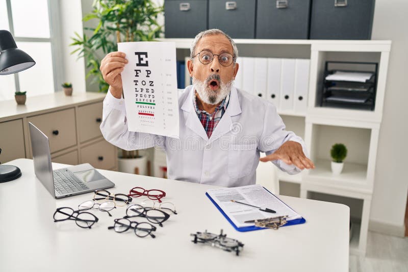 Un homme âgé effrayé par la surprise ouvre sa bouche dans l'incrédulité pendant le test oculaire à la clinique images libres de droits