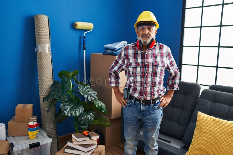 Un homme âgé gai avec un sourire cool montre du matériel de sécurité à sa nouvelle maison photographie stock libre de droits
