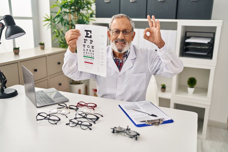 Un homme âgé joyeux donne ok signe avec des doigts souriant brillamment pendant le test de vision à la clinique gesturant excellen images stock