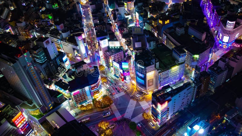 Un horario nocturno de la ciudad neón en shibuya cruzando el gran ángulo de inclinación del disparo