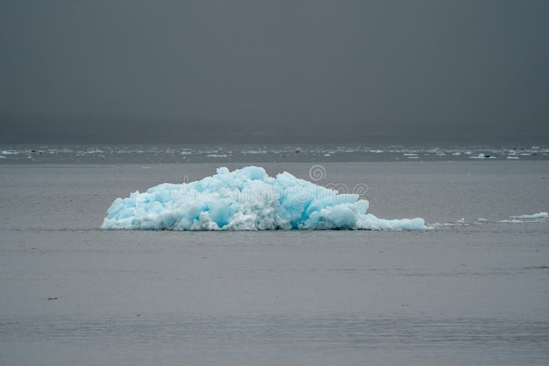 Un iceberg blu solo da un ghiacciaio si siede nella baia di resurrezione immagine stock Un iceberg blu solo da un ghiacciaio si siede nella baia di resurrezione immagine stock