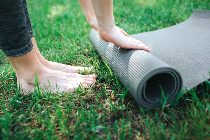 Un'immagine delle gambe e delle mani femminili del ` s La ragazza sta rotolando sul carimate Fine in su Yoga e concetto di Pilate fotografia stock libera da diritti Un'immagine delle gambe e delle mani femminili del ` s La ragazza sta rotolando sul carimate Fine in su Yoga e concetto di Pilate fotografia stock libera da diritti