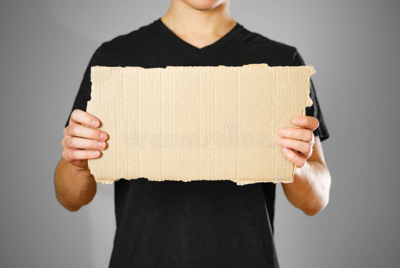 Un individuo joven en una camiseta negra que sostiene un pedazo de cartulina Pre imagenes de archivo Un individuo joven en una camiseta negra que sostiene un pedazo de cartulina Pre imagenes de archivo