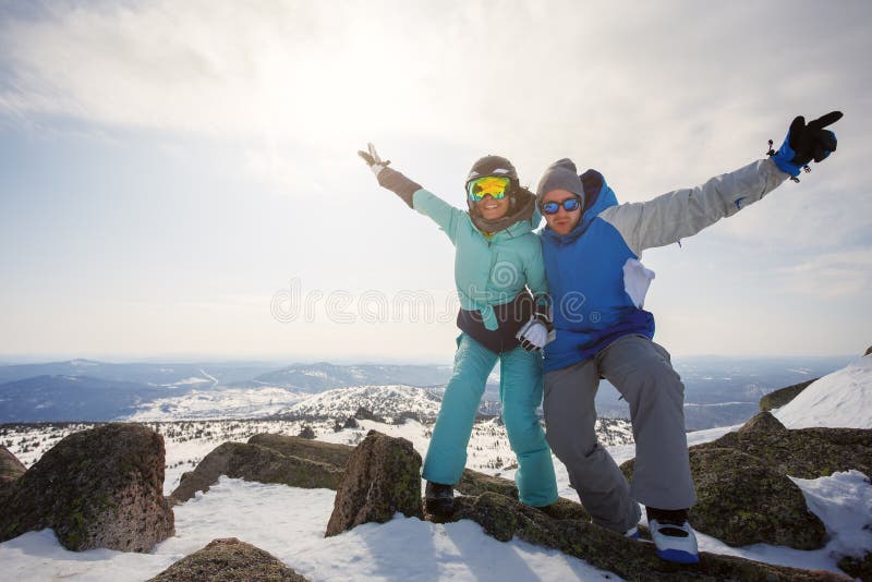 Un individuo y snowboarders de una muchacha en la cima de la montaña con th imagen de archivo Un individuo y snowboarders de una muchacha en la cima de la montaña con th imagen de archivo