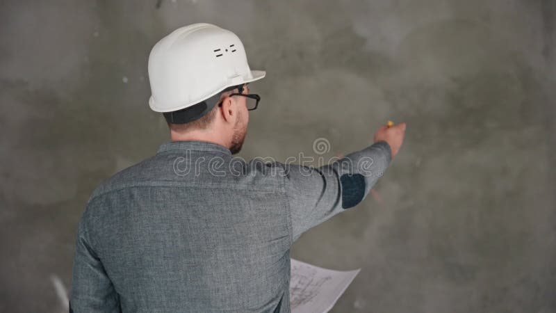 Un ingegnere edile e un caposquadra ispezionano il cantiere e discutono i progressi dei lavori di costruzione. la stock footage