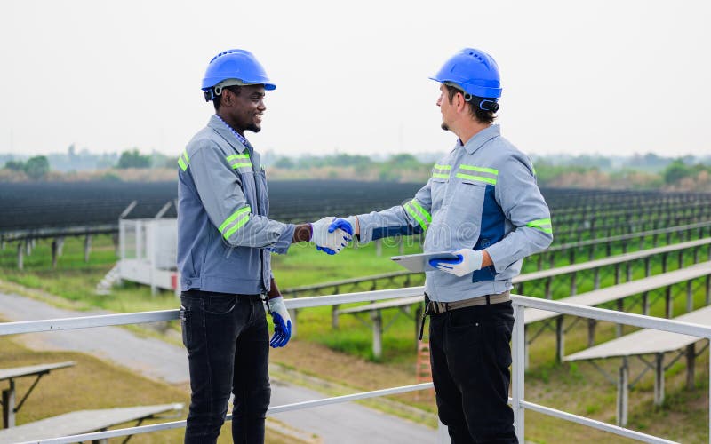 Un ingénieur d'entretien heureux qui vérifie et entretient le système de panneaux solaires photographie stock libre de droits