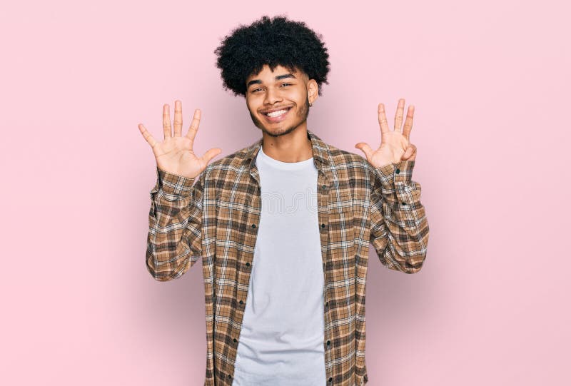 Un jeune afro-américain aux cheveux afro portant des vêtements décontractés montrant et pointant avec les doigts numéro neuf tout photographie stock libre de droits