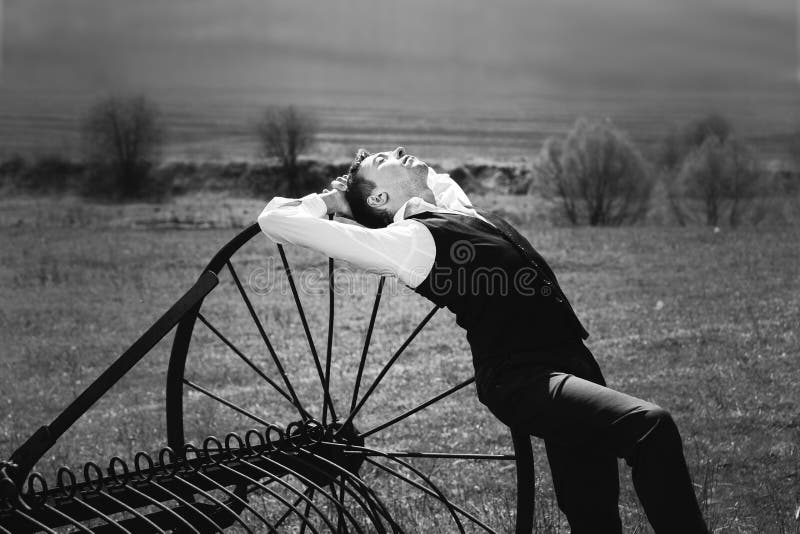 Un jeune homme dans une chemise blanche, un gilet noir et des pantalons noirs se trouve image libre de droits Un jeune homme dans une chemise blanche, un gilet noir et des pantalons noirs se trouve image libre de droits
