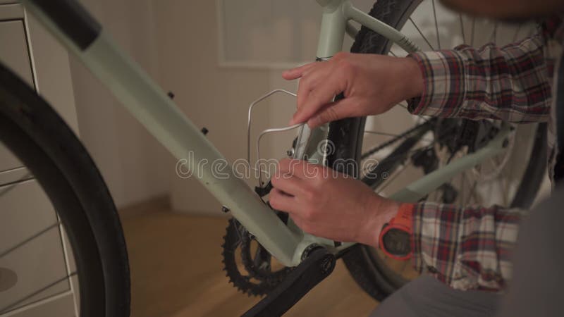 Un Jeune Homme Installe Un Accessoire De Vélo à La Maison Dans Un Studio.  Un Jeune Homme Met Un Vélo à La Maison. Fixation Mâle Banque De Vidéos -  Vidéo du gravier