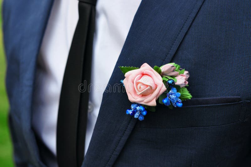 Un jeune homme mince dans un costume classique avec un lien et une chemise blanche et une rose dans sa boutonnière photos stock Un jeune homme mince dans un costume classique avec un lien et une chemise blanche et une rose dans sa boutonnière photos stock
