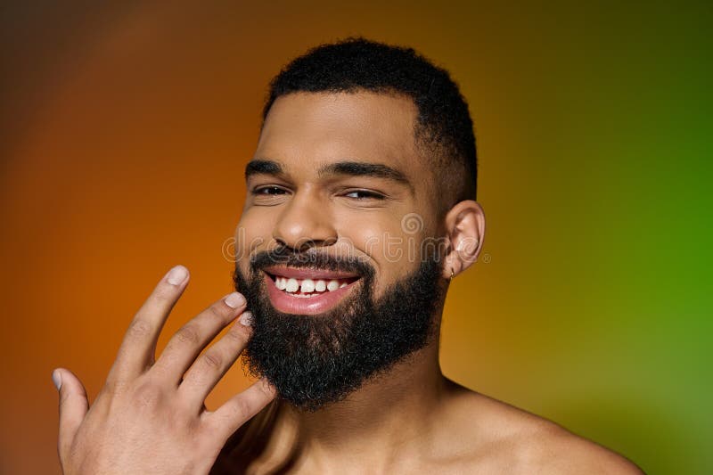 A smiling young man with a beard showcasing his skincare routine, stock photo. A smiling young man with a beard showcasing his skincare routine, stock photo