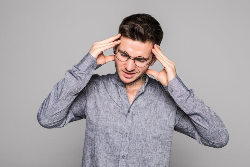 Un jeune homme stressant ressent de terribles maux de tête, frustré et déprimé, se serre les dents dans la douleur, souffre de ma photo stock Un jeune homme stressant ressent de terribles maux de tête, frustré et déprimé, se serre les dents dans la douleur, souffre de ma photo stock