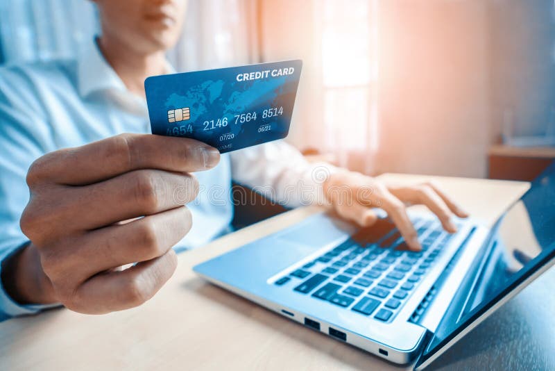 Un jeune homme utilise la carte de crédit pour acheter en ligne images libres de droits