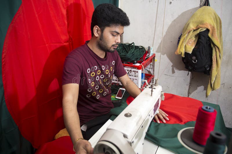 Un jeune tailleur Md Rashed Alam, vieillissent 28 drapeaux nationaux bangladais de fabrication chez Dhaka, Bangladesh photographie stock libre de droits Un jeune tailleur Md Rashed Alam, vieillissent 28 drapeaux nationaux bangladais de fabrication chez Dhaka, Bangladesh photographie stock libre de droits