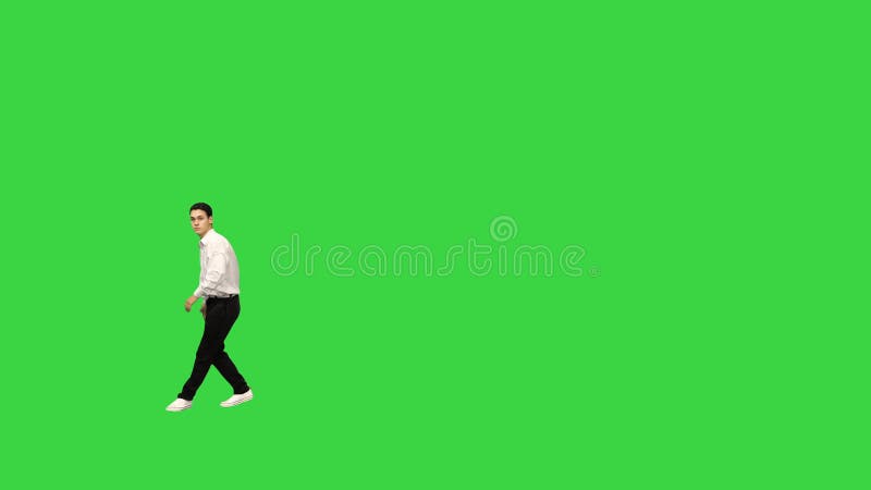 Un joven con camisa blanca haciendo reverso mirando la cámara y caminando en una llave cromática de pantalla verde.