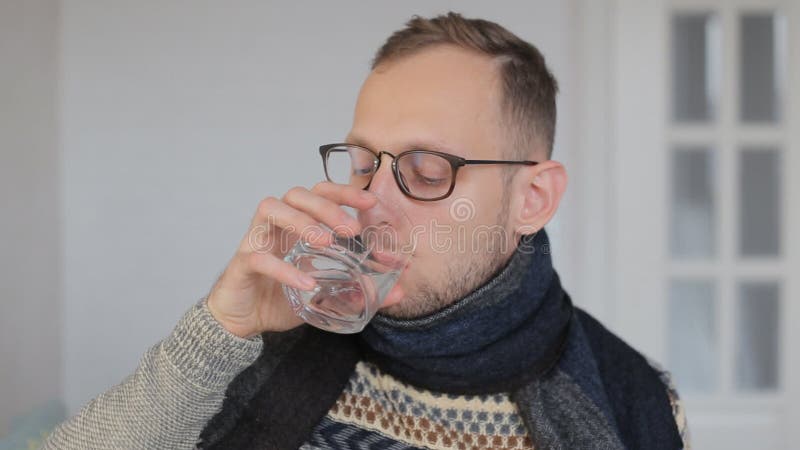 Un joven europeo enfermo con bufanda está tomando un antibiótico metrajes
