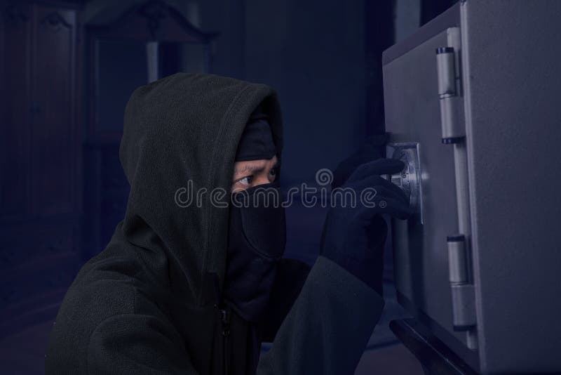 Un ladro che prova ad aprire una scatola di sicurezza