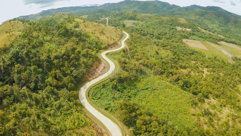 Un largo y una carretera con curvas que pasan a través de las colinas verdes Isla de Busuanga Coron Silueta del hombre de negocio imagen de archivo Un largo y una carretera con curvas que pasan a través de las colinas verdes Isla de Busuanga Coron Silueta del hombre de negocio imagen de archivo