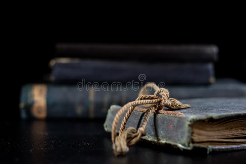 Un libro vecchio che si trova su una tavola nera Nei precedenti un mucchio di fotografia stock