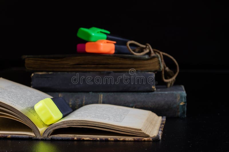 Un libro vecchio che si trova su una tavola nera Nei precedenti un mucchio di fotografia stock