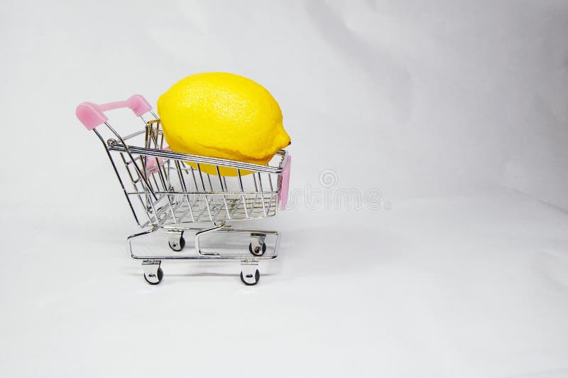 Un limone on/inside il mini carrello di compera fotografia stock Un limone on/inside il mini carrello di compera fotografia stock