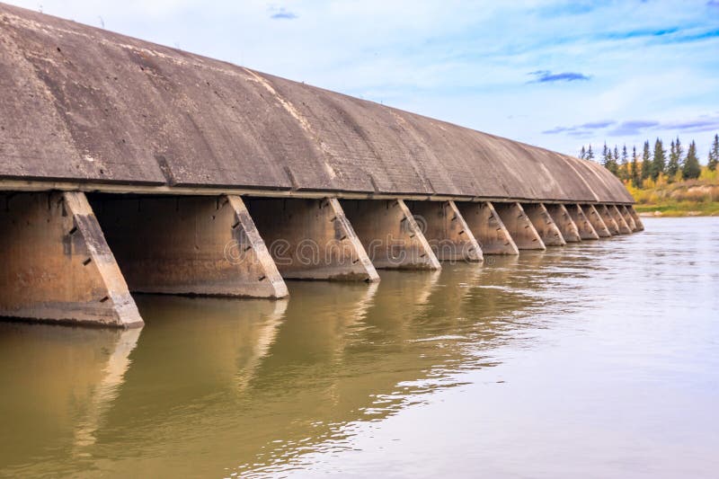 Un long pont avec une rangée d'arcs se reflète dans l'eau images stock