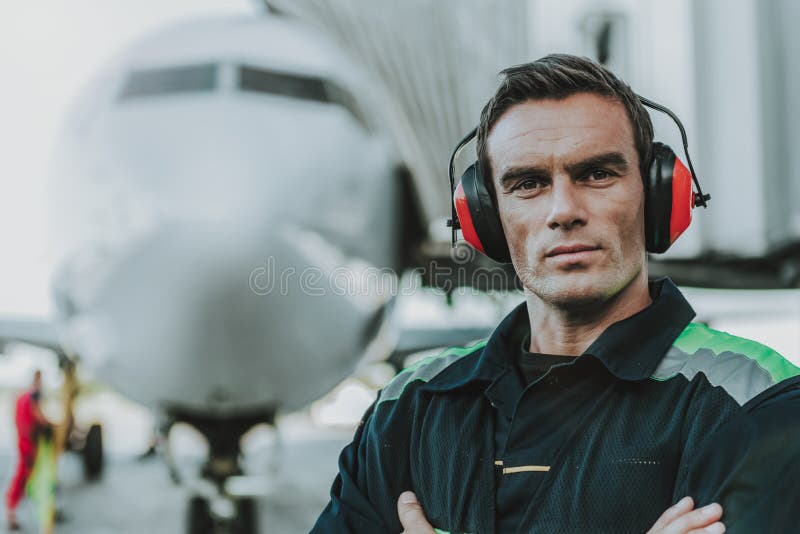 Un lucrător chipeș grav care are un loc de muncă pe aerodromuri royalty free stock image