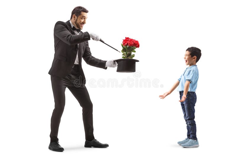 Un mago che mostra un trucco magico a un ragazzino felice fotografia stock