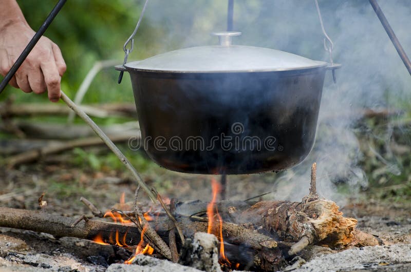 Un Man X27 La Main De S Allume Un Feu Sous Une Casserole