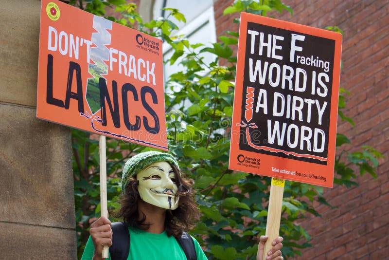 Un manifestante joven con una máscara encendido en las protestas antis-Fracking en Preston imagen de archivo