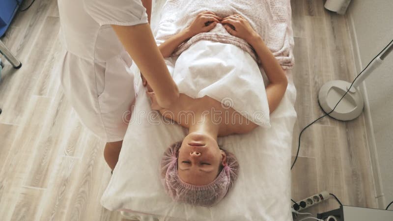 Un masseur donne à une femme un massage facial professionnel. la salle de massage procède à un rajeunissement