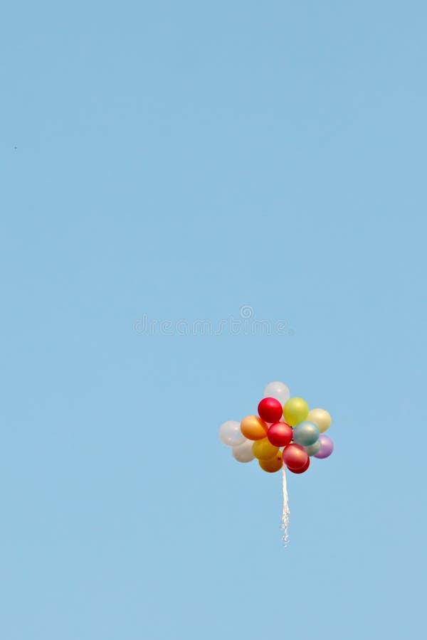 Un mazzo di palloni dipinti in un cielo blu che vola via immagini stock libere da diritti Un mazzo di palloni dipinti in un cielo blu che vola via immagini stock libere da diritti
