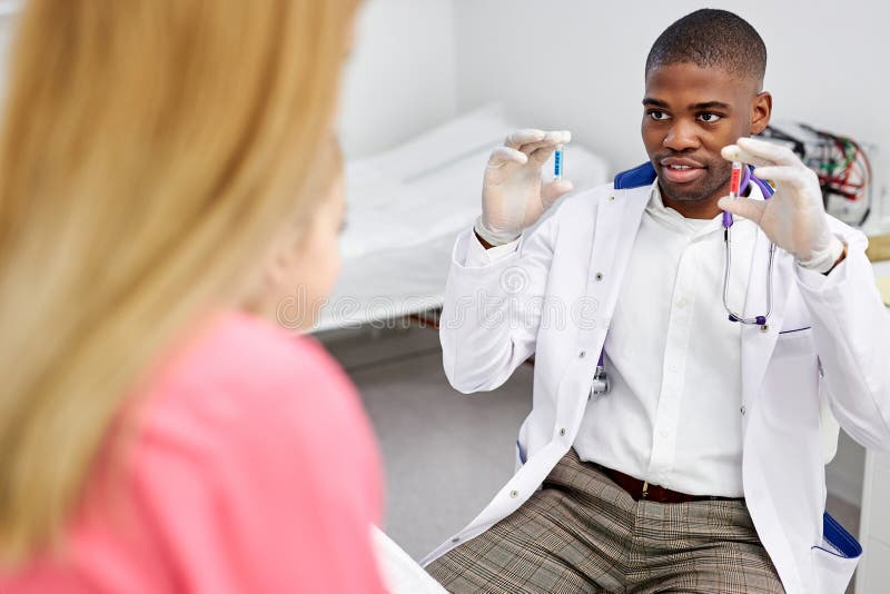 Un medico africano ha fatto una bella chiacchierata con una ragazzina con capsule colorate immagini stock libere da diritti