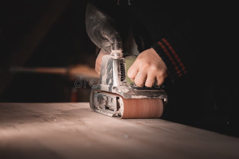 Un menuisier travaille dans un atelier. menuiserie meuble. un charpentier broie une partie en bois images libres de droits