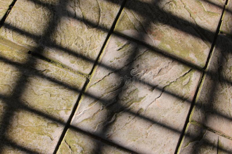 A pattern of shadows across weathered slate paving slabs. A pattern of shadows across weathered slate paving slabs