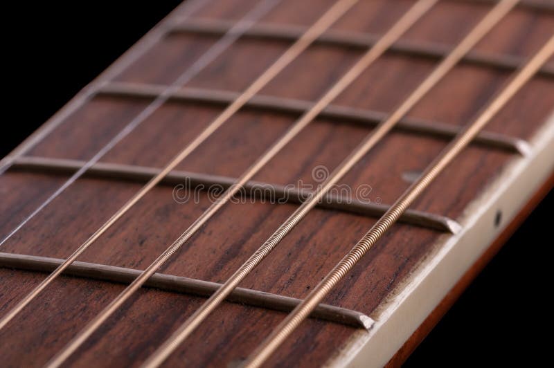 Un morceau de fretboard avec des frettes et des ficelles d'une guitare acoustique photo stock Un morceau de fretboard avec des frettes et des ficelles d'une guitare acoustique photo stock