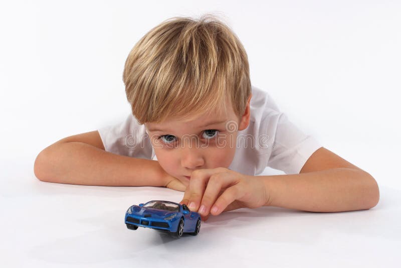 Un muchacho del niño capturado mientras que juega con los juguetes del coche imagen de archivo Un muchacho del niño capturado mientras que juega con los juguetes del coche imagen de archivo