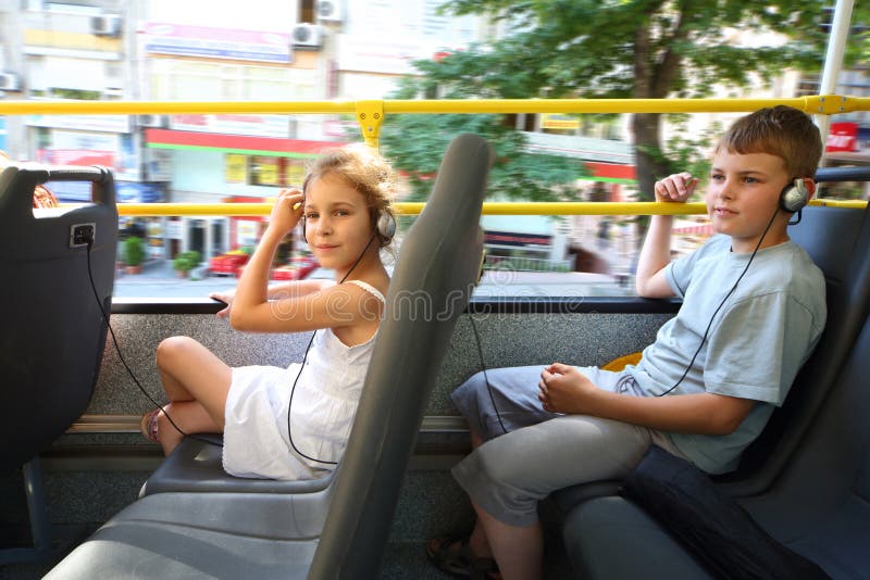 Un muchacho y una muchacha que viajan en un bus turístico foto de archivo libre de regalías Un muchacho y una muchacha que viajan en un bus turístico foto de archivo libre de regalías