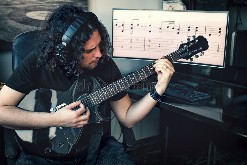 Un musicista con cuffie coi capelli lunghi, che suona la chitarra elettrica con uno spartito musicale sullo sfondo dello schermo