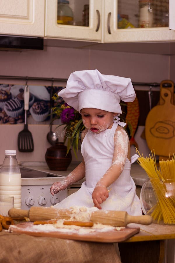 Un Niño Pequeño Con Ropa De Cocinero Roba La Masa Con Un Alfiler