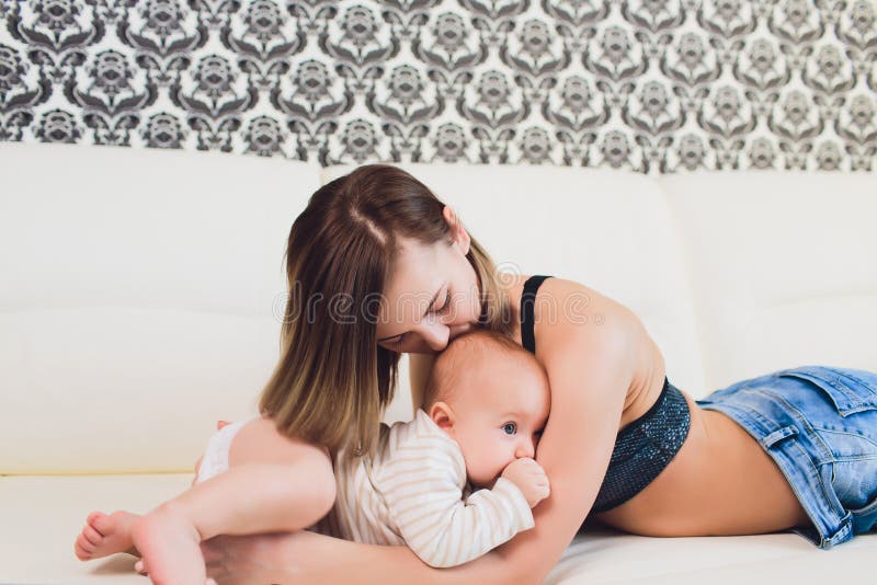 Un ni?o de la madre y del beb? en una cama blanca foto de archivo libre de regalías Un ni?o de la madre y del beb? en una cama blanca foto de archivo libre de regalías